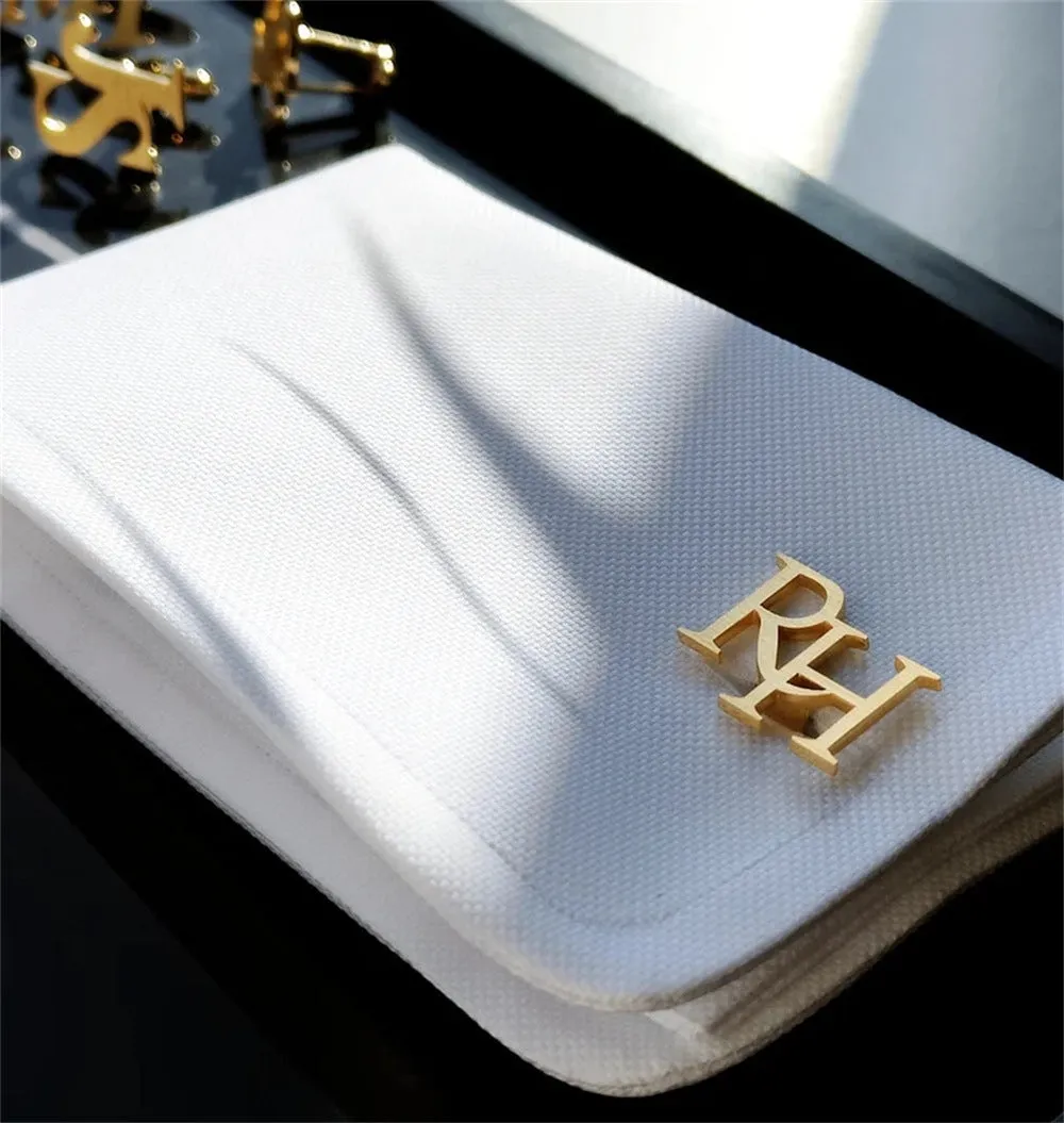 Handmade frosted personalised name abbreviation metal cufflinks in gold colour on a grey background