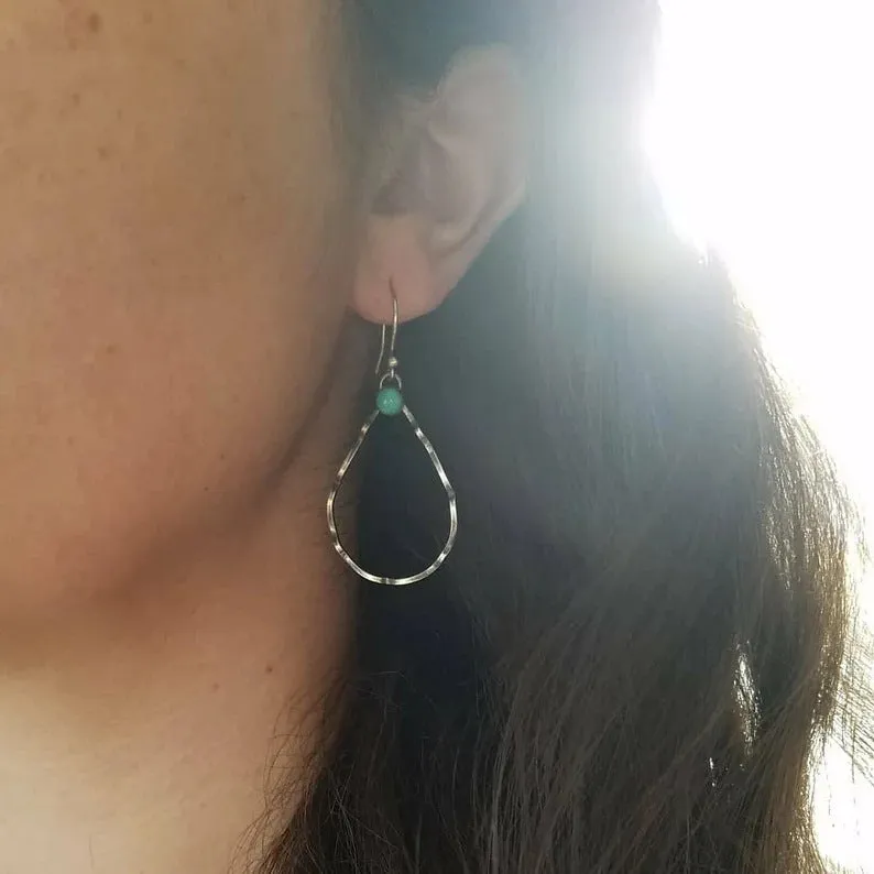 A pair of vintage-style bohemian earrings with turquoise circles and geometric shapes in antique silver alloy.