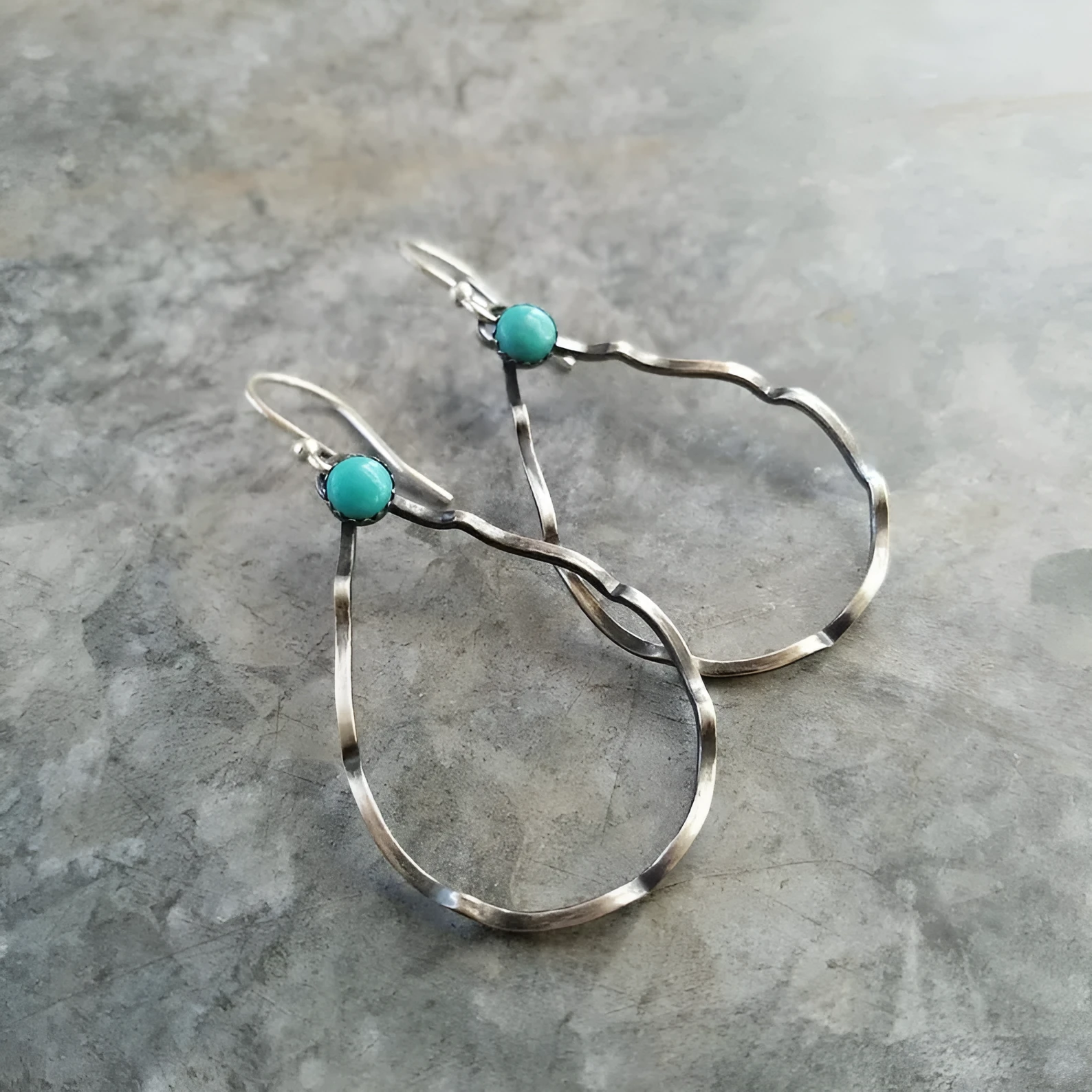 A pair of vintage-style bohemian earrings with turquoise circles and geometric shapes in antique silver alloy.