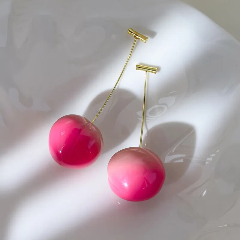 A pair of coloured acrylic peach fruit earrings on copper posts, shown in small and large size options.