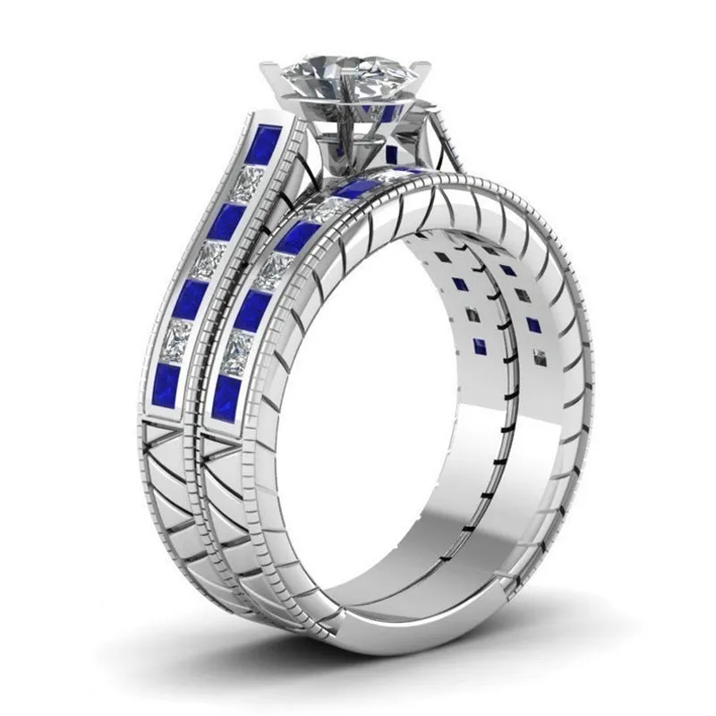 Blue alloy couple ring set with white diamond-style detail on white background