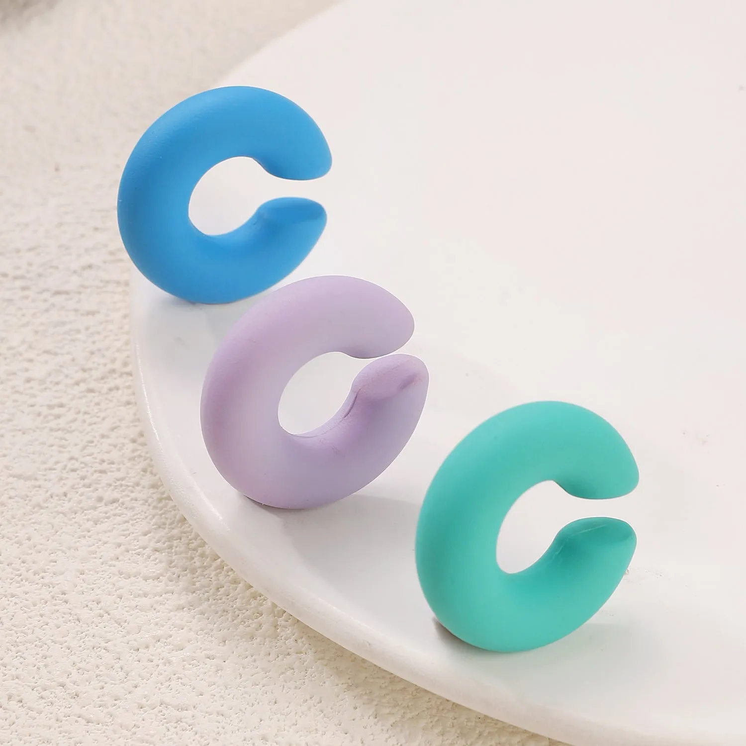 A pair of matte finish, coarse round C-shaped clip-on earrings for women in a choice of fifteen candy colours.