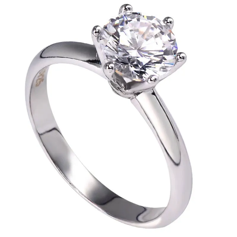 White gold plated six-claw zircon ring with a geometric design on a finger.