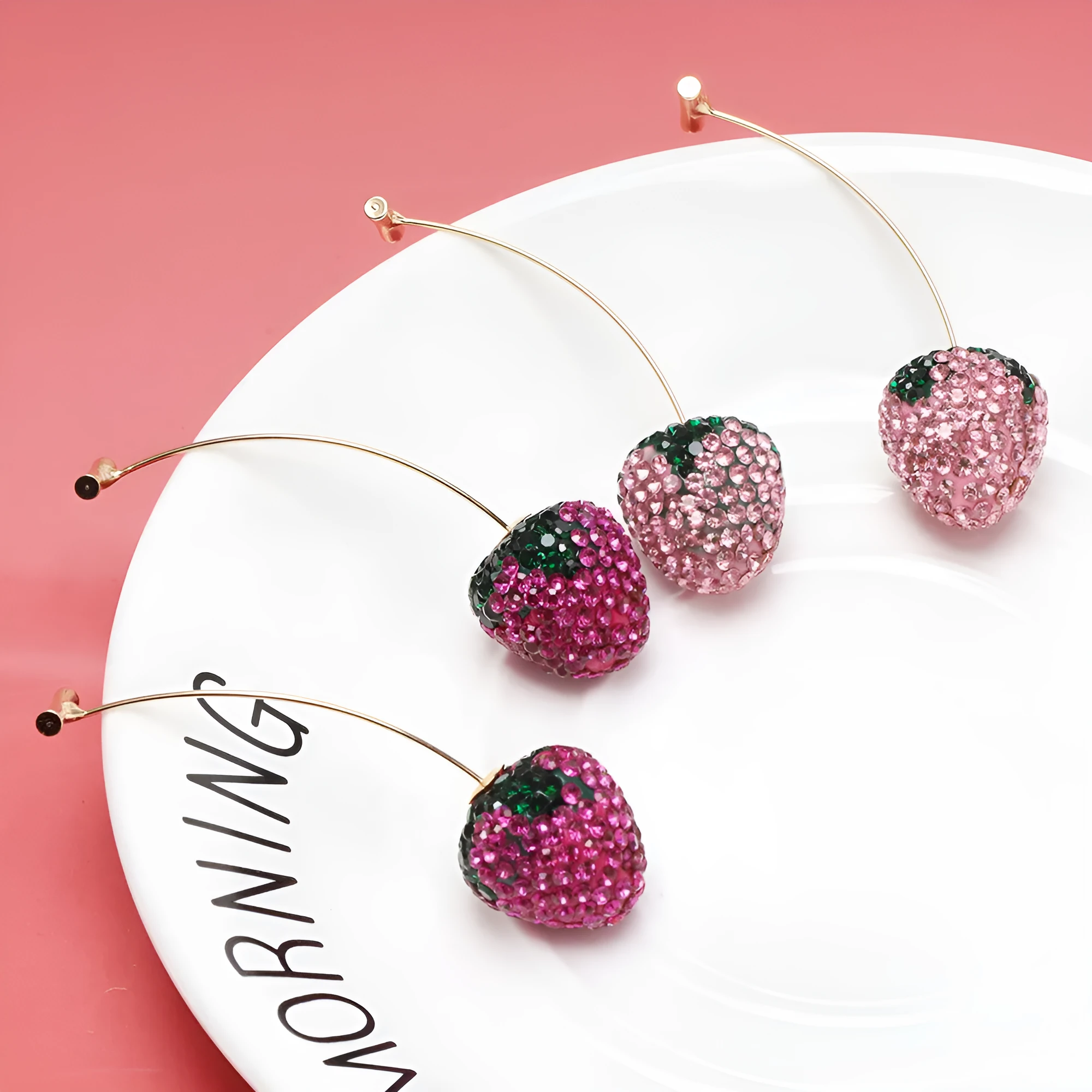 Red strawberry charm stud earrings with spot drill finish on zinc alloy.