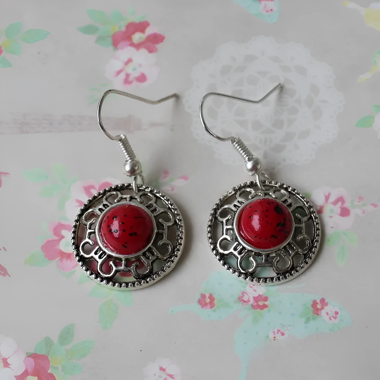 Handmade silver and turquoise ethnic earrings with geometric flower disk and traditional patterns.