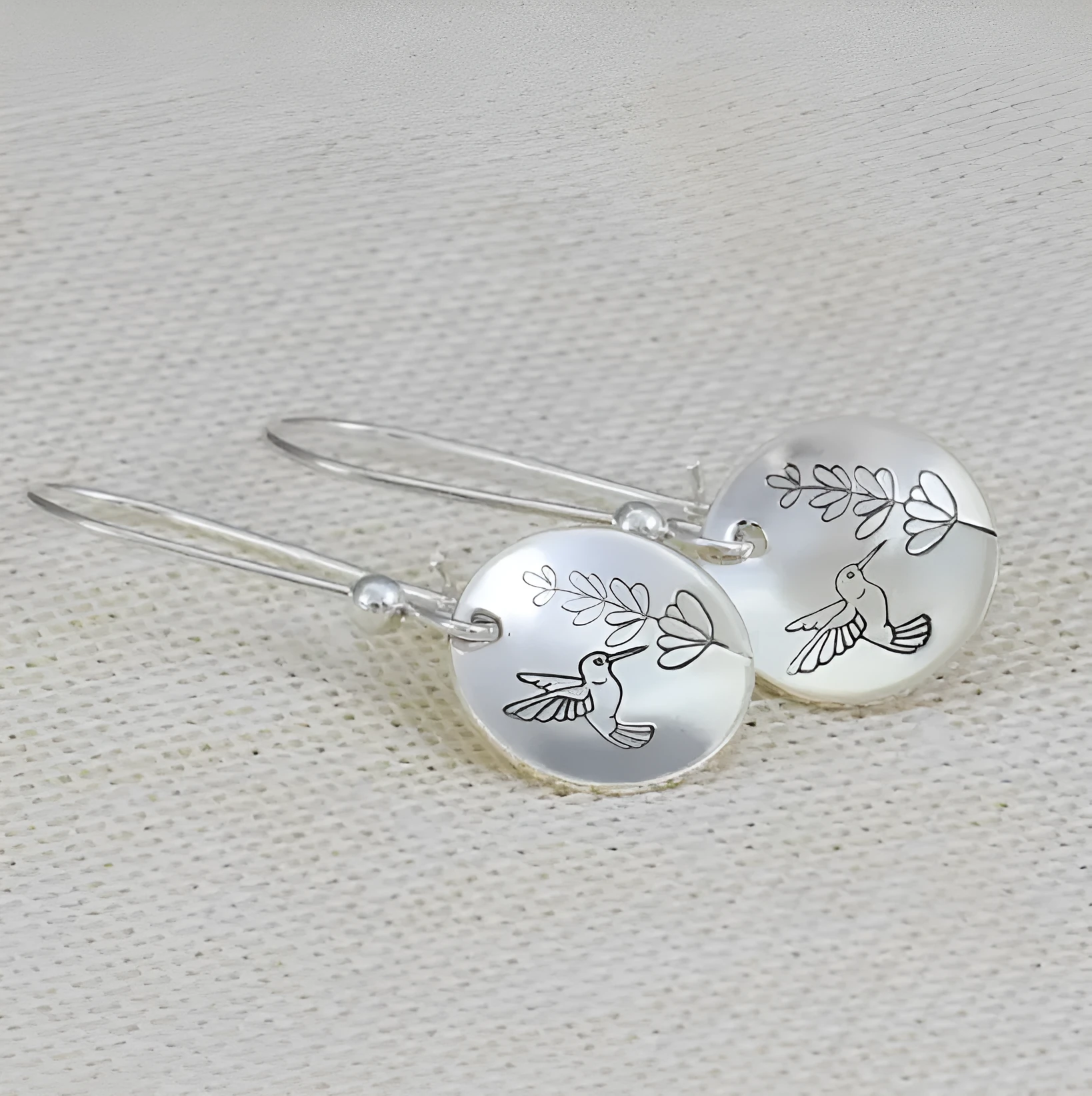 Silver glossy round women's earrings with bird and leaf motif