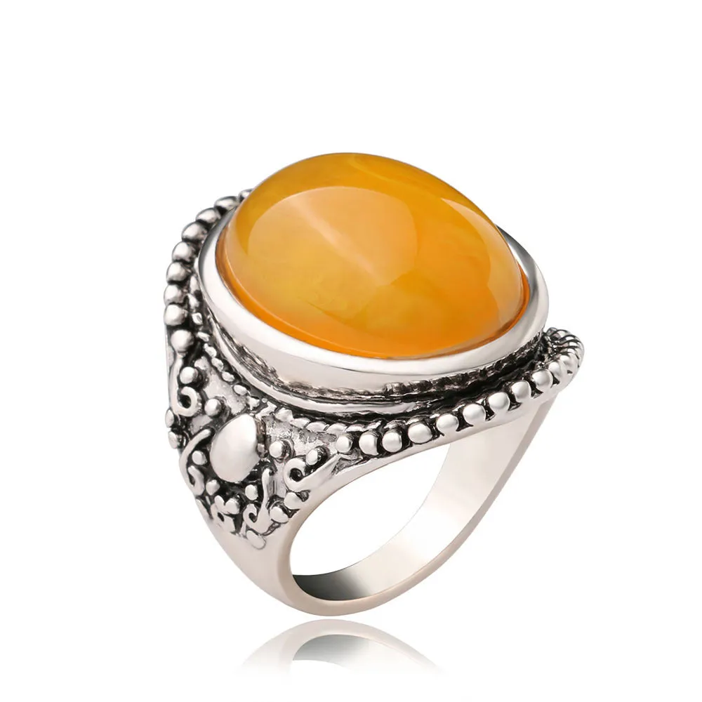 Geometric retro alloy ring in antique silver amber colour on a grey background.