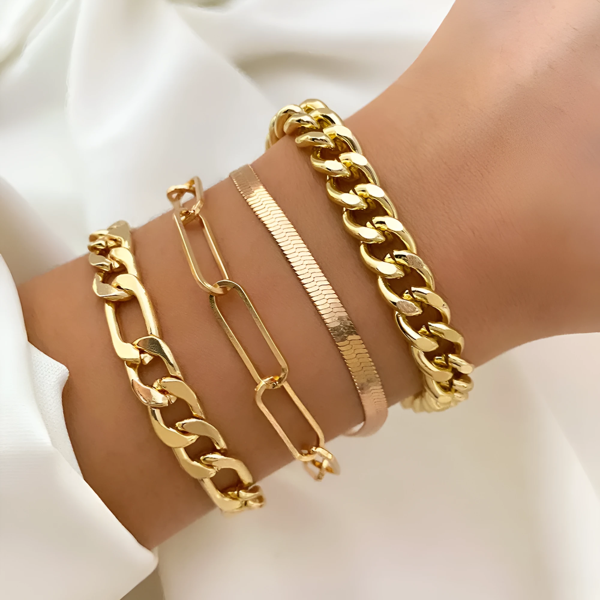 Set of four gold electroplated alloy bracelets on a surface