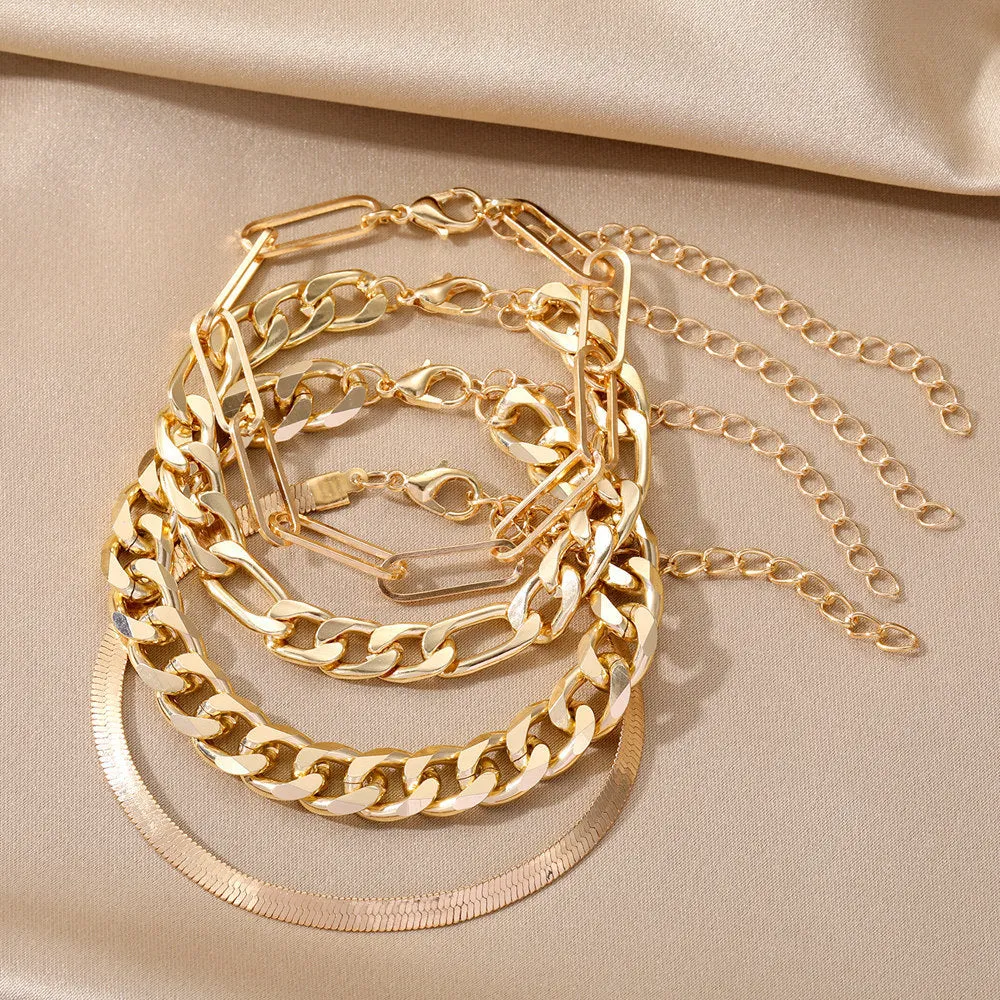 Set of four gold electroplated alloy bracelets on a surface