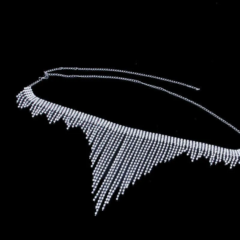 Silvery rhinestone body chain laid flat on a white surface showing metal links and clear stones