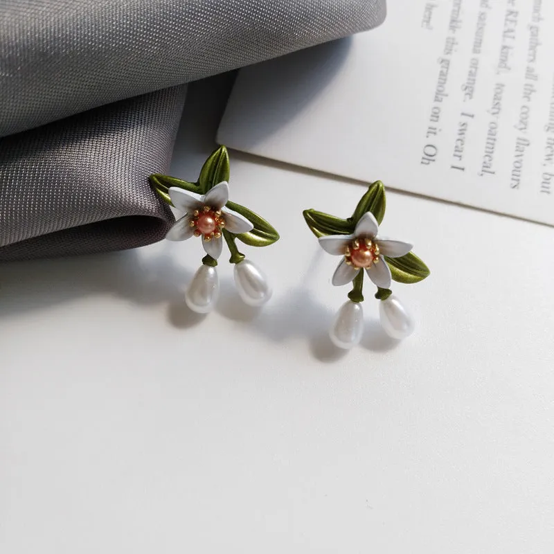 A pair of alloy flower earrings for women, showing sterling silver needle flower studs and a matching flower clip-on style.