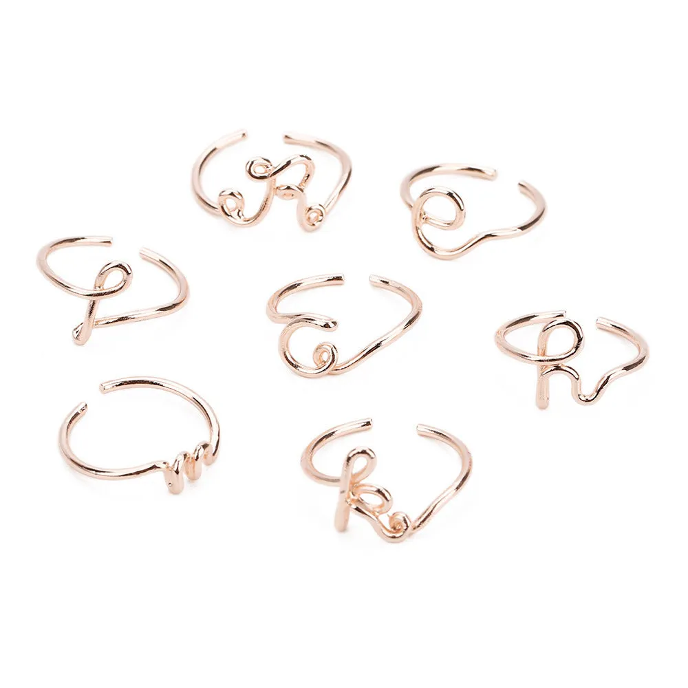 Gold coloured unisex alloy initial ring with letter A geometric shape on a flat surface