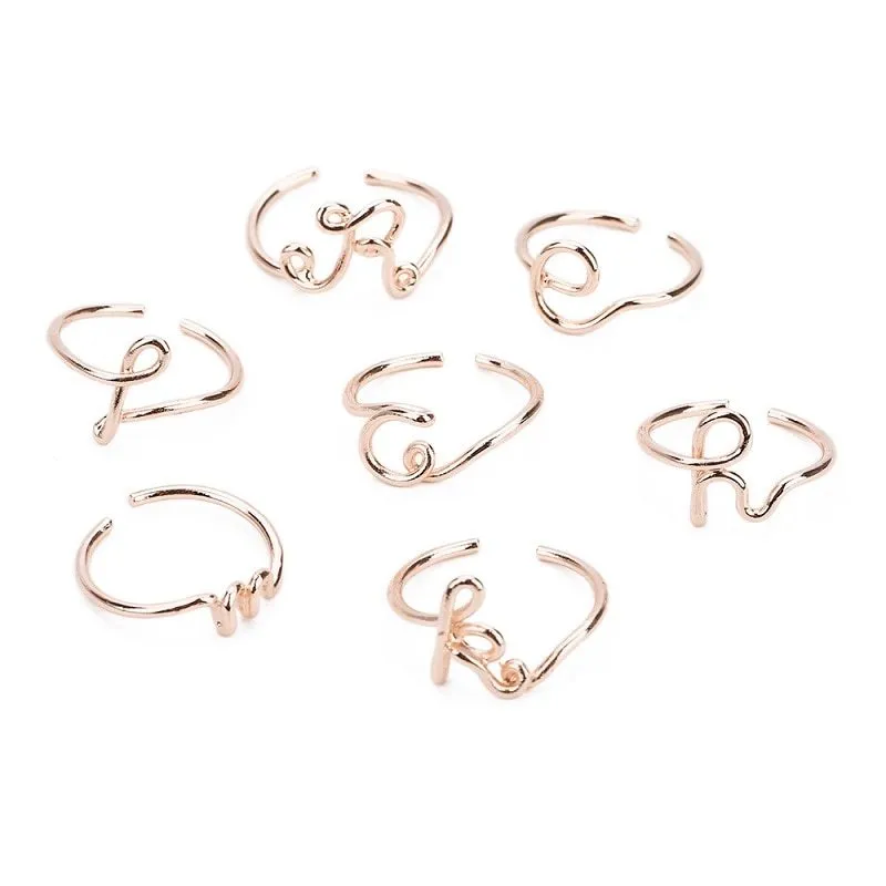 Gold coloured unisex alloy initial ring with letter A geometric shape on a flat surface