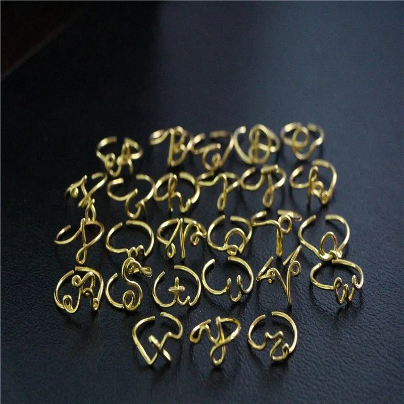 Gold coloured unisex alloy initial ring with letter A geometric shape on a flat surface