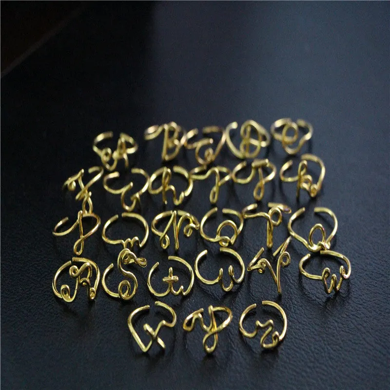 Gold coloured unisex alloy initial ring with letter A geometric shape on a flat surface