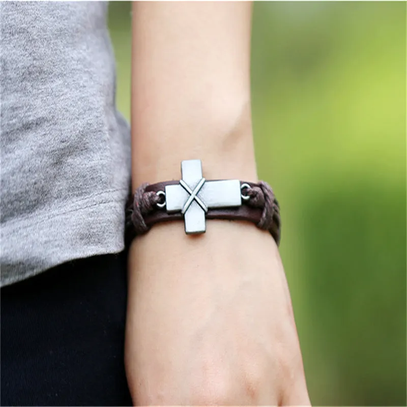 Brown leather cross bracelet with alloy accent, adjustable drawstring, vintage style on wrist