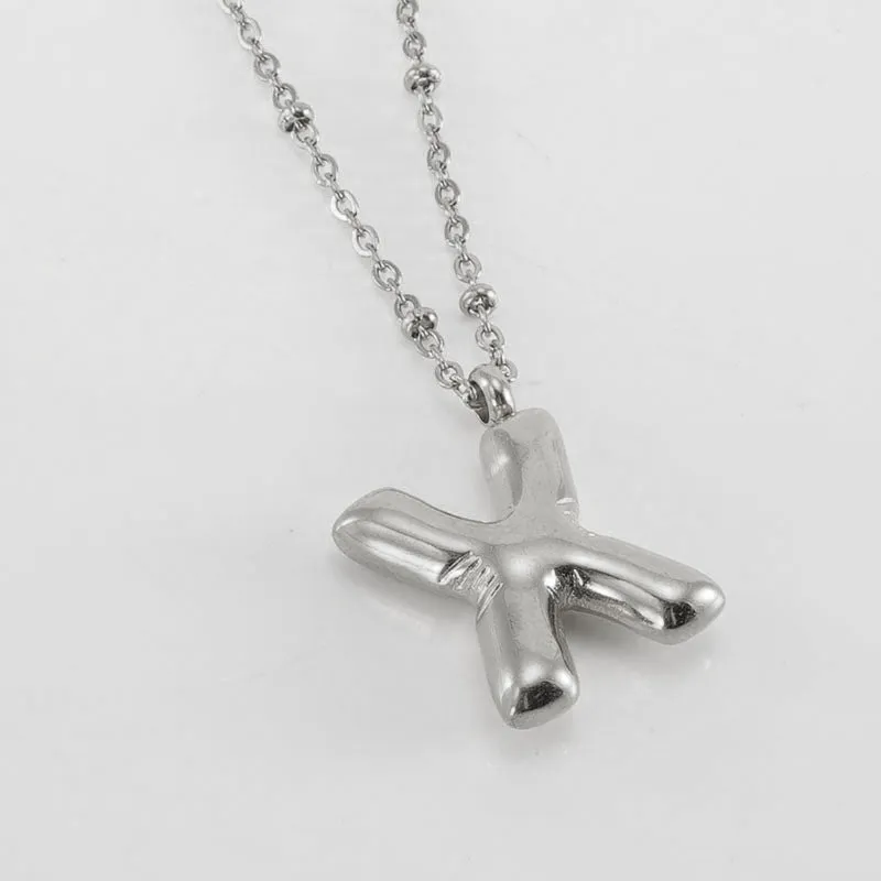 Gold bubble letter N pendant on stainless steel clip beads chain necklace against white background