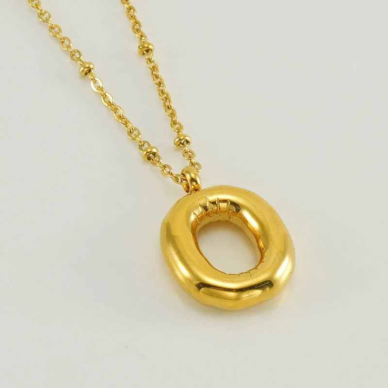 Gold bubble letter N pendant on stainless steel clip beads chain necklace against white background
