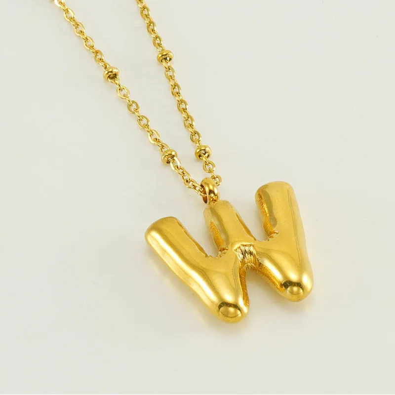 Gold bubble letter N pendant on stainless steel clip beads chain necklace against white background