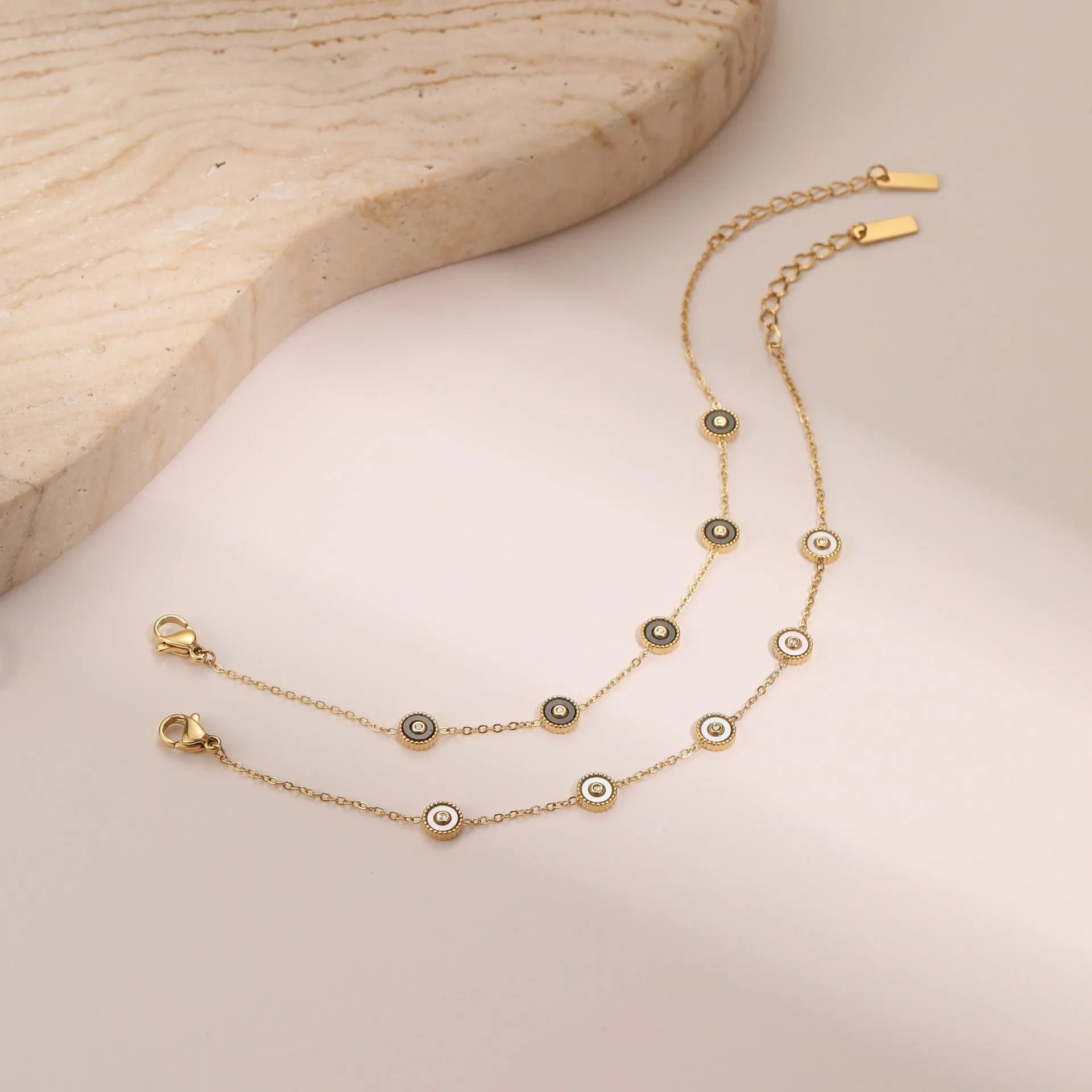 Women's stainless steel bracelet with 18K gold plating and geometric fritillary charm, includes matching necklace
