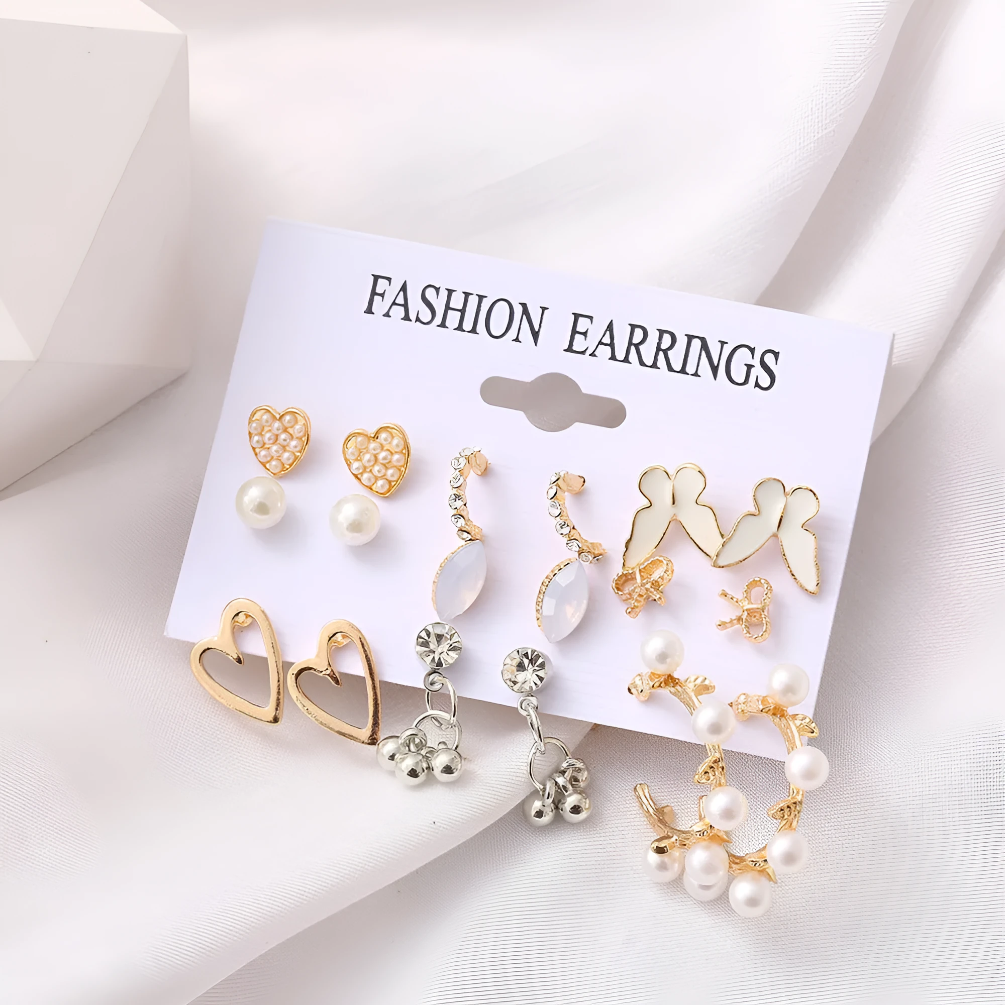 Nine pairs of gold alloy earrings with butterfly and love designs arranged together