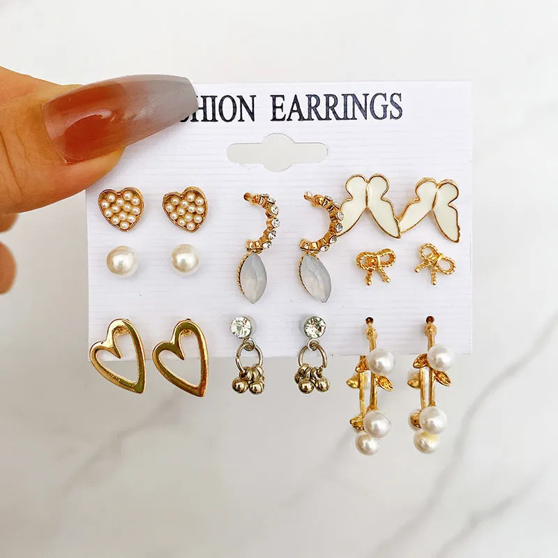 Nine pairs of gold alloy earrings with butterfly and love designs arranged together