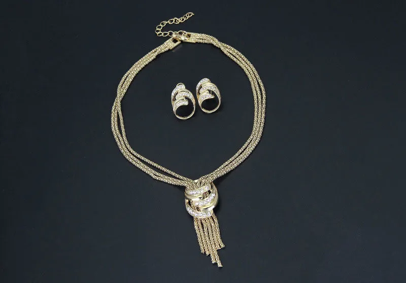 Gold alloy jewelry set with necklace, bracelet, earrings, and ring on a neutral background