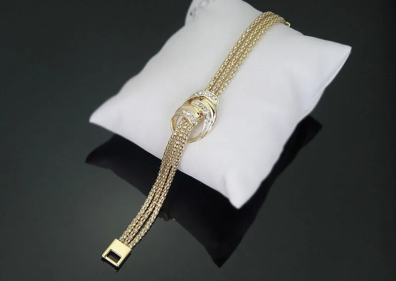 Gold alloy jewelry set with necklace, bracelet, earrings, and ring on a neutral background