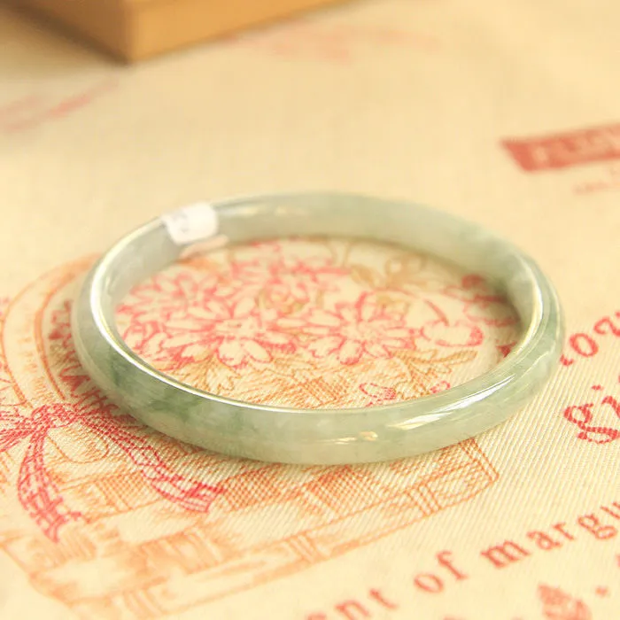 Traditional green jade waxy Chinese bracelet with geometric design showing 10mm profile