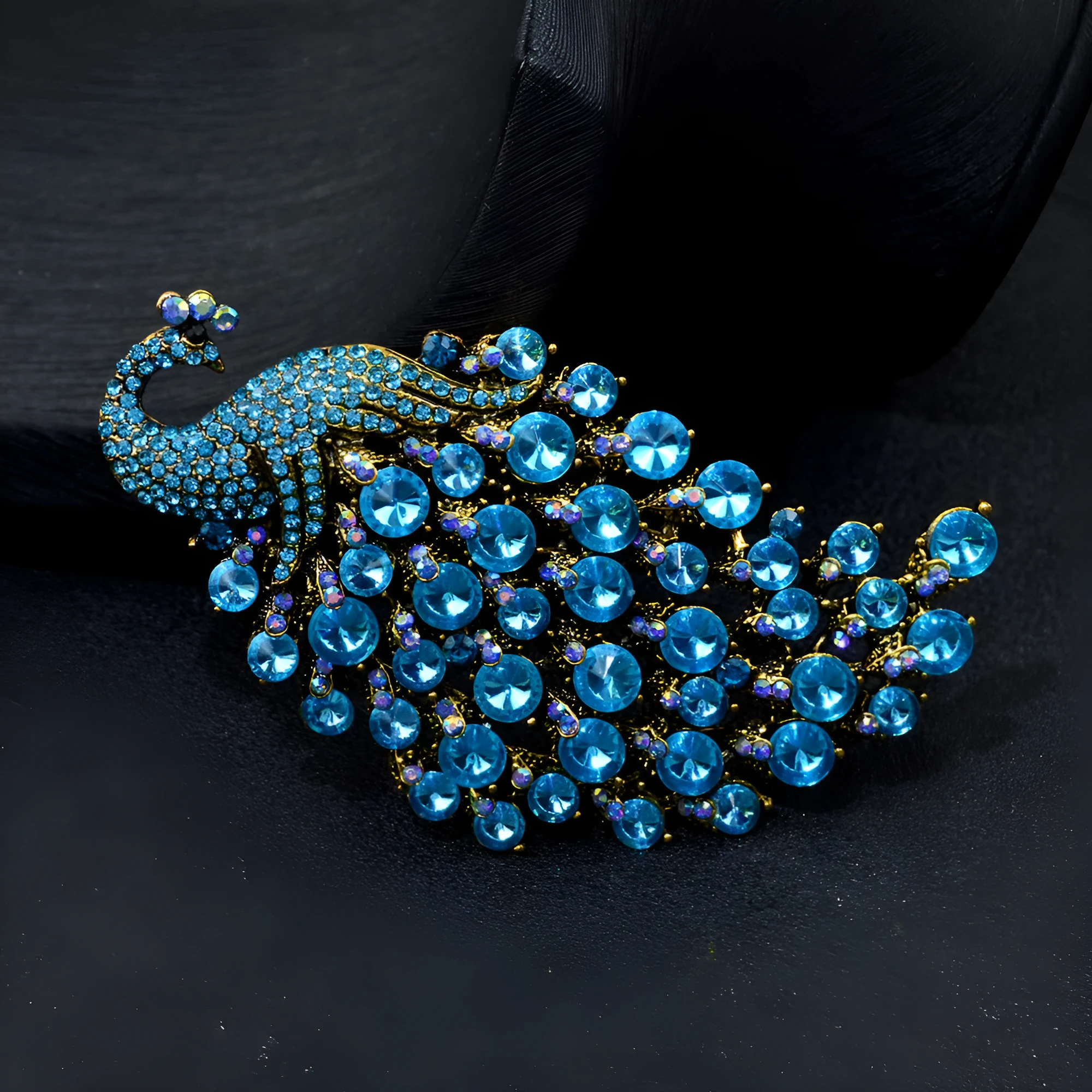 Colourful metal peacock brooch in red, green, and blue with rhinestone accents on a white background