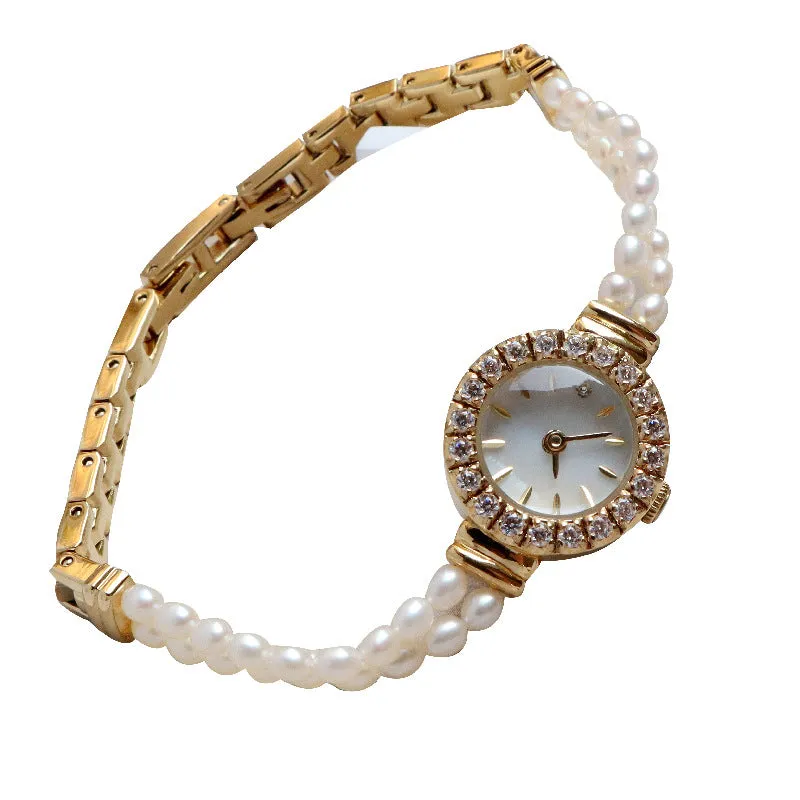 Light gold women's bracelet watch with freshwater pearls, an 18mm round dial, and a stainless steel folding buckle.