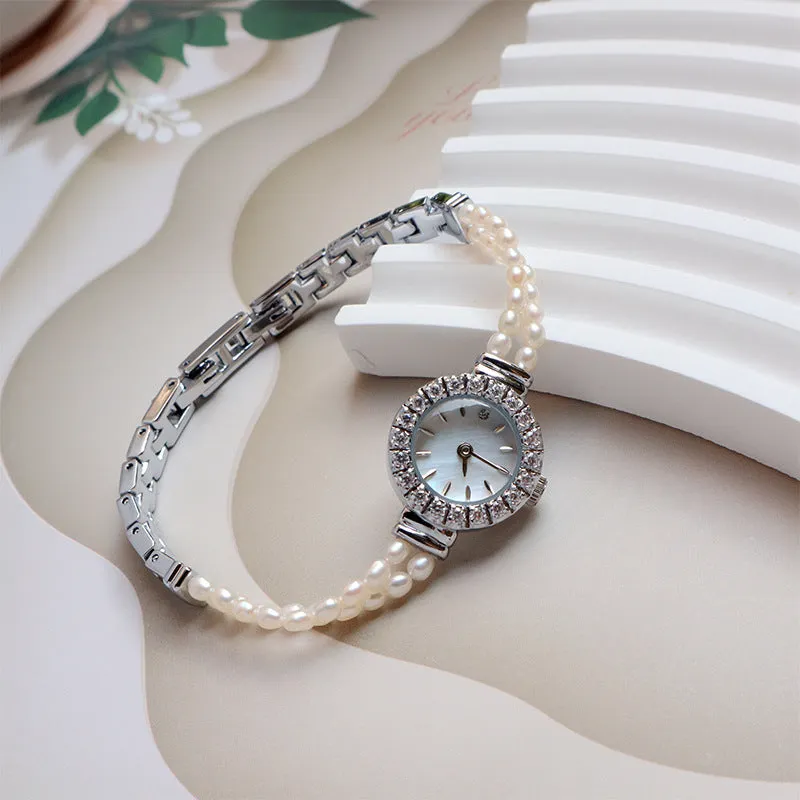 Light gold women's bracelet watch with freshwater pearls, an 18mm round dial, and a stainless steel folding buckle.