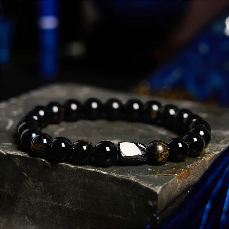 Natural obsidian bracelet with constellation design, 8mm wide, on a wrist.