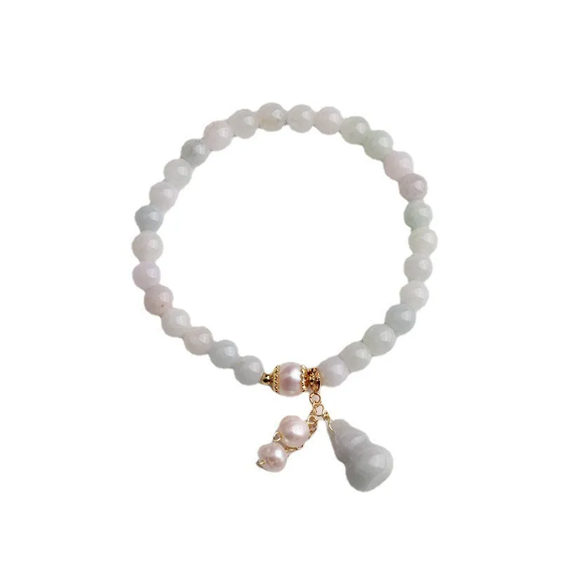 Chinese style jade bracelet with gourd charm and pearl accents on wrist