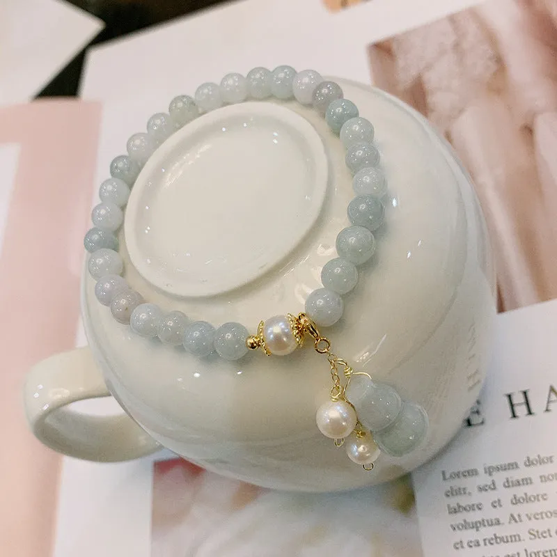 Chinese style jade bracelet with gourd charm and pearl accents on wrist