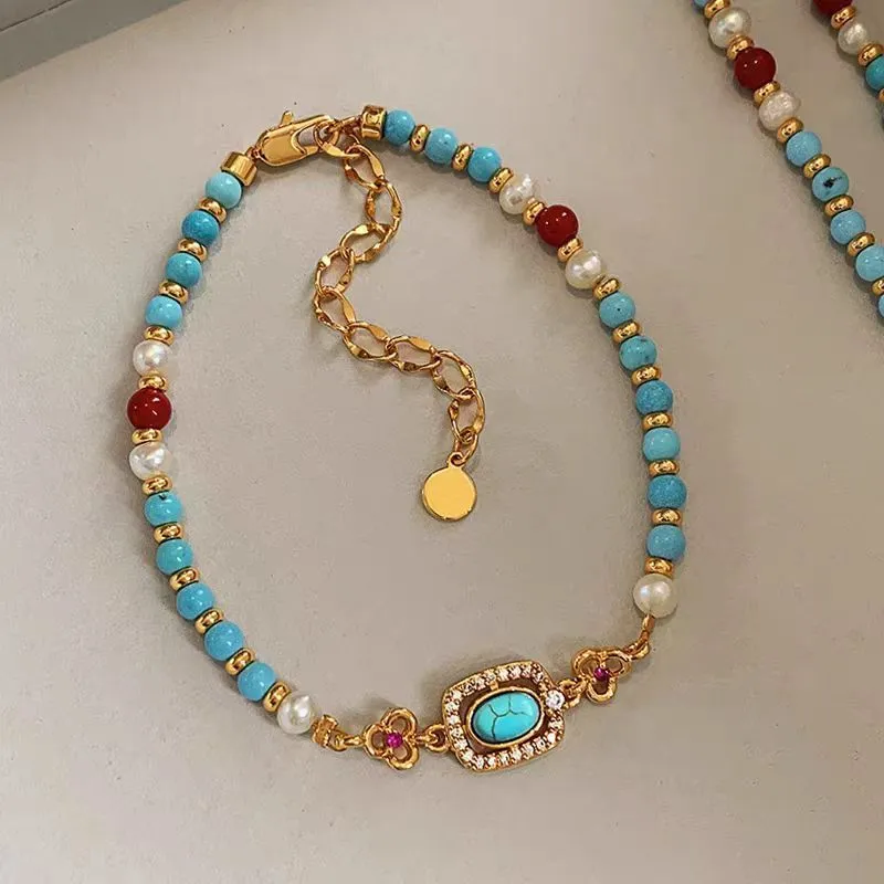 Natural turquoise pearl necklace with gold plated copper chain and matching bracelet on display