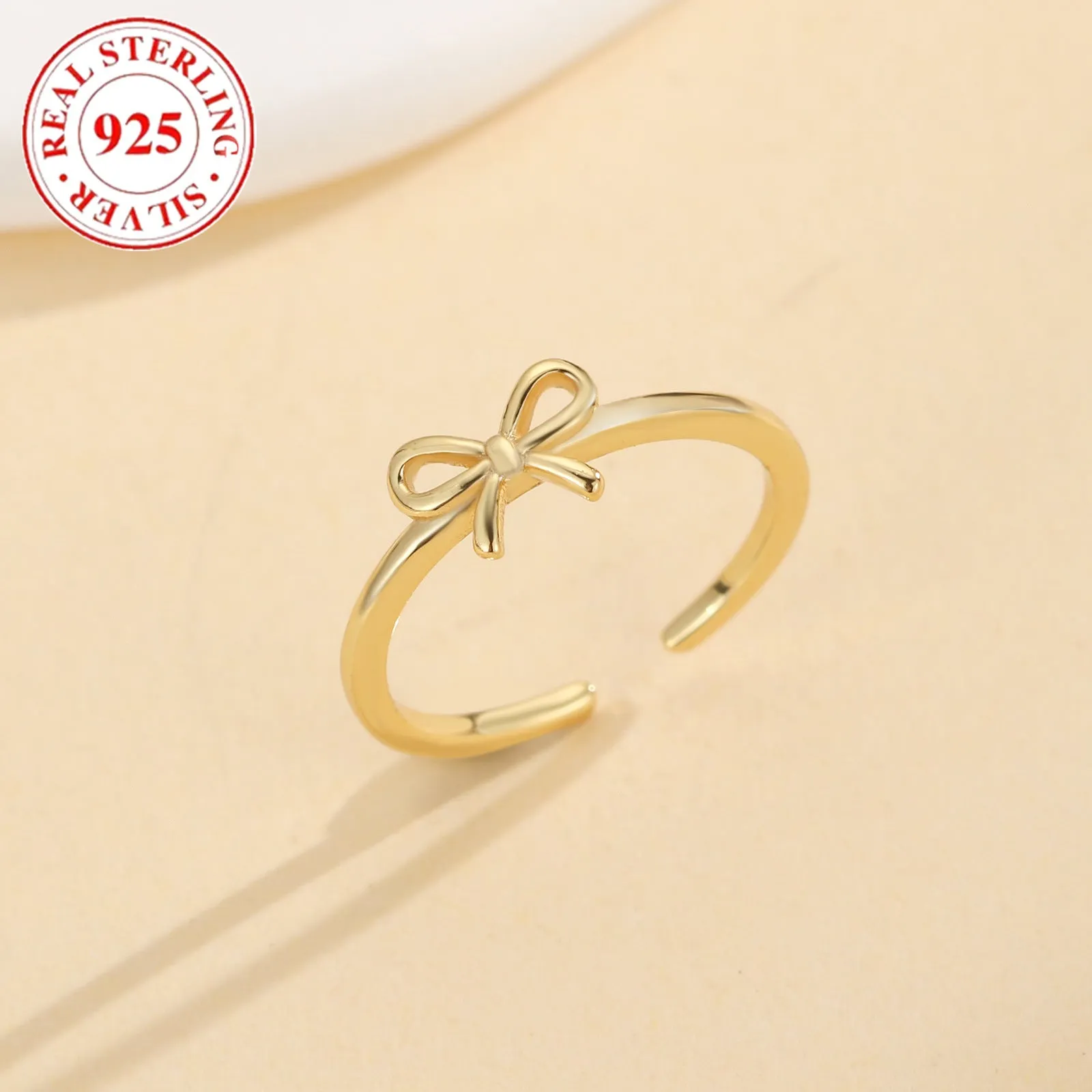S925 sterling silver bow opening toe ring in gold F026 on a woman's toe