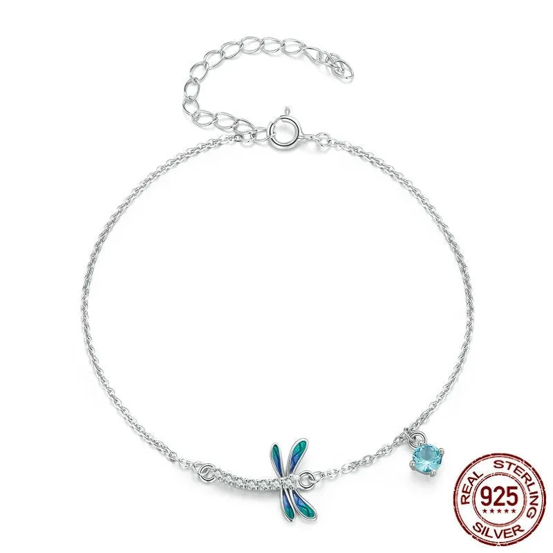 Sterling silver white gold plated dragonfly bracelet with dripping cubic zirconia stones on a light background