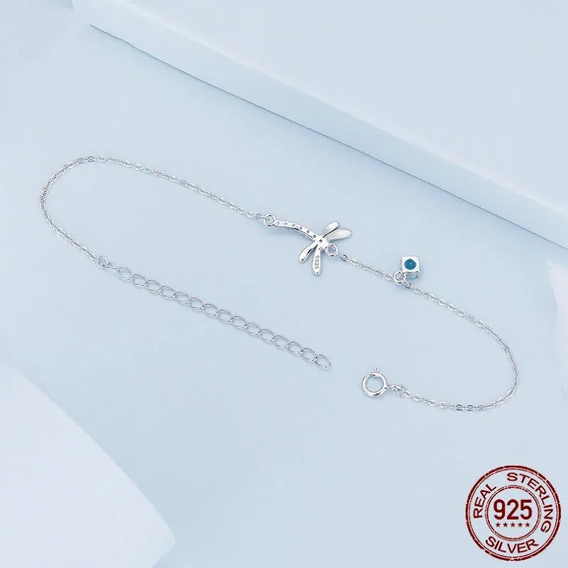 Sterling silver white gold plated dragonfly bracelet with dripping cubic zirconia stones on a light background