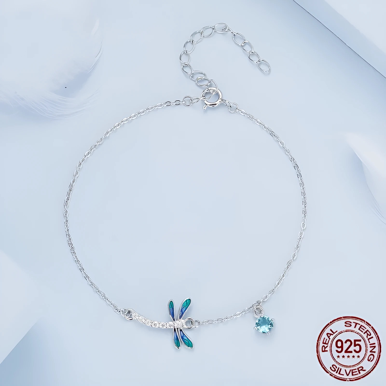 Sterling silver white gold plated dragonfly bracelet with dripping cubic zirconia stones on a light background