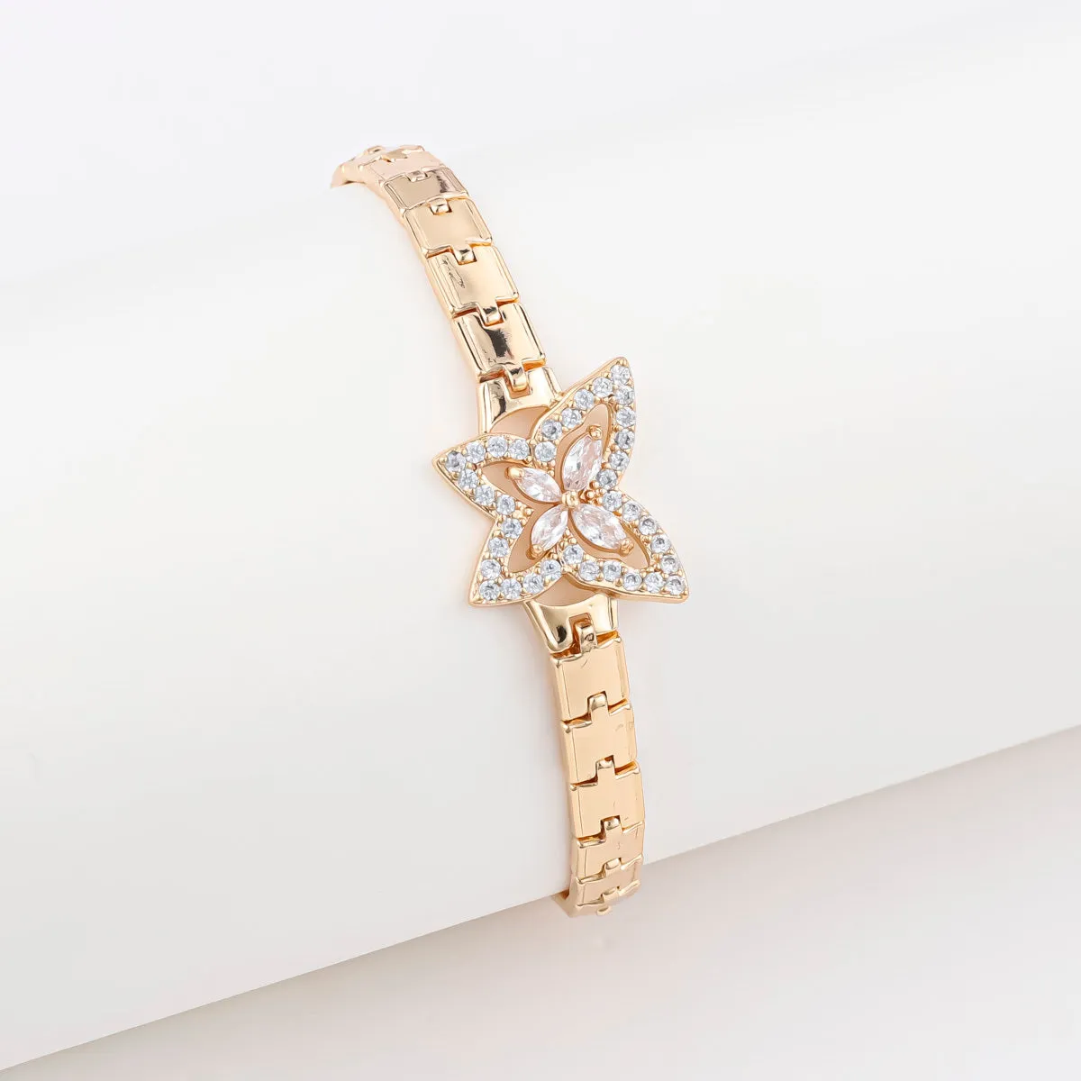 18K gold-plated butterfly clover brass bracelet with zircon stone on plain background