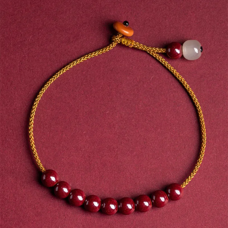 Hand-woven bracelet made from raw cinnabar and Hetian jade beads in a geometric design.