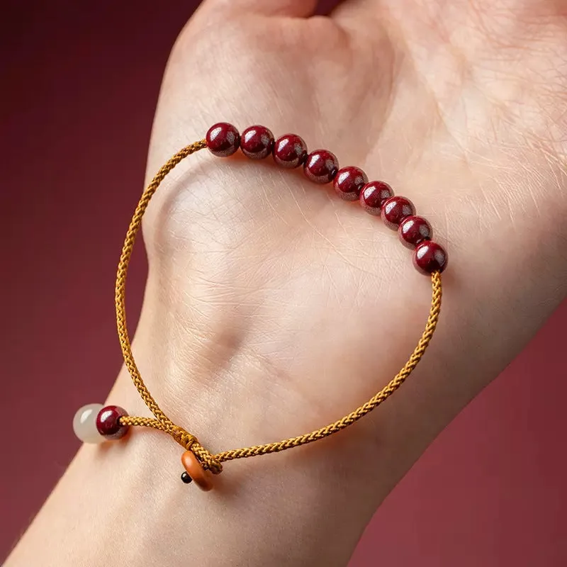 Hand-woven bracelet made from raw cinnabar and Hetian jade beads in a geometric design.