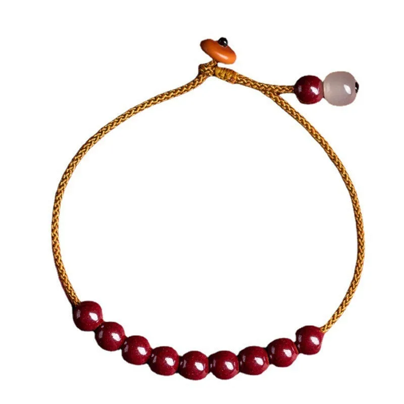 Hand-woven bracelet made from raw cinnabar and Hetian jade beads in a geometric design.