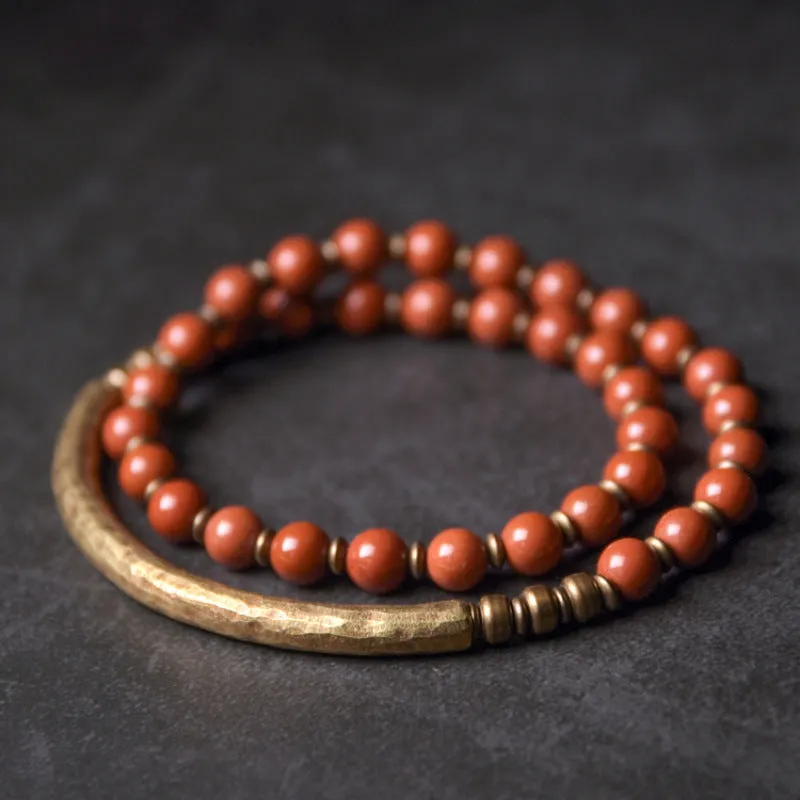 Layered retro bracelet with natural stone beads and brass details on a wrist.