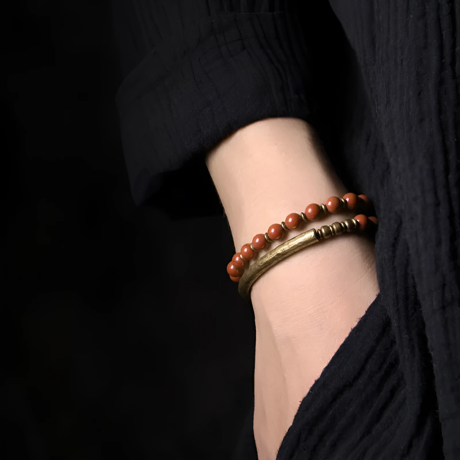Layered retro bracelet with natural stone beads and brass details on a wrist.