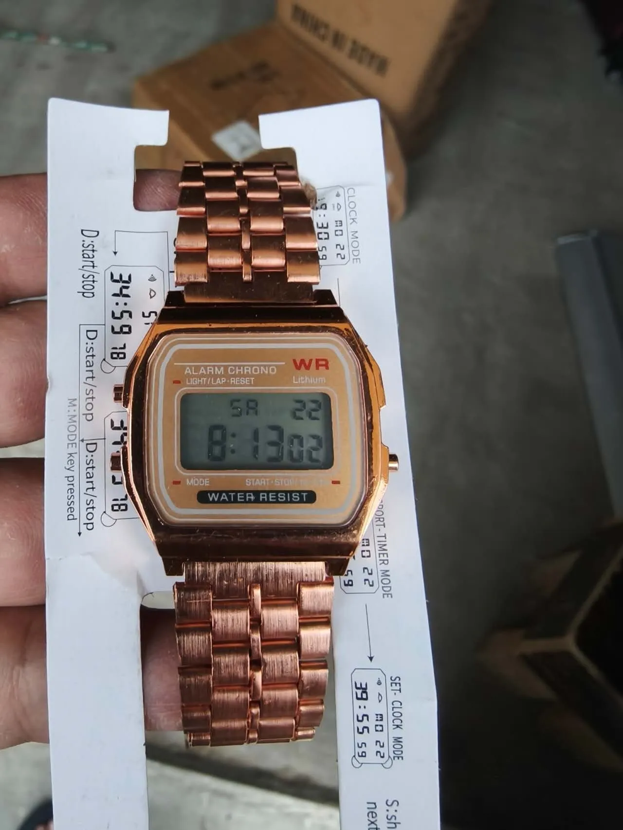 Rose gold analogue watch with round stainless steel case, luminous hands, and date display on a white background