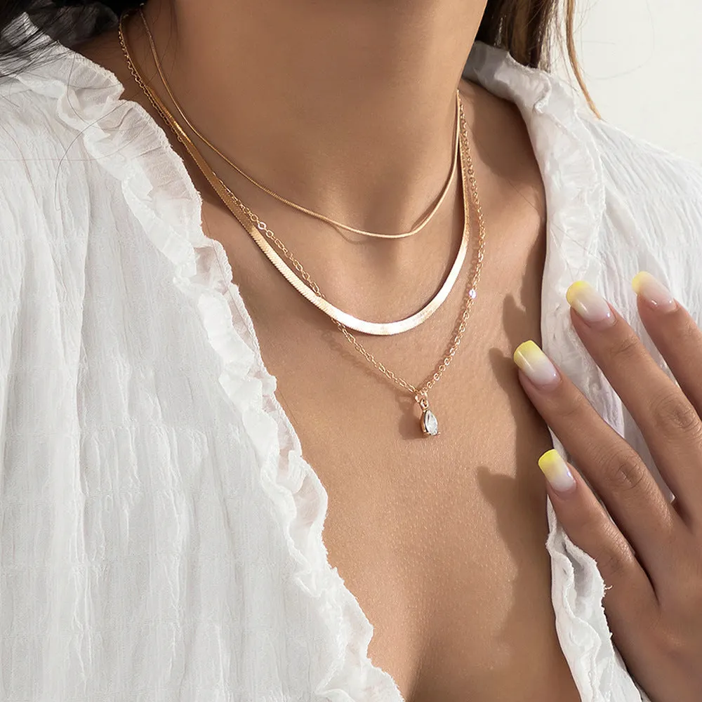 Gold and silver water drop shape alloy pendant necklace with electroplated finish on white background