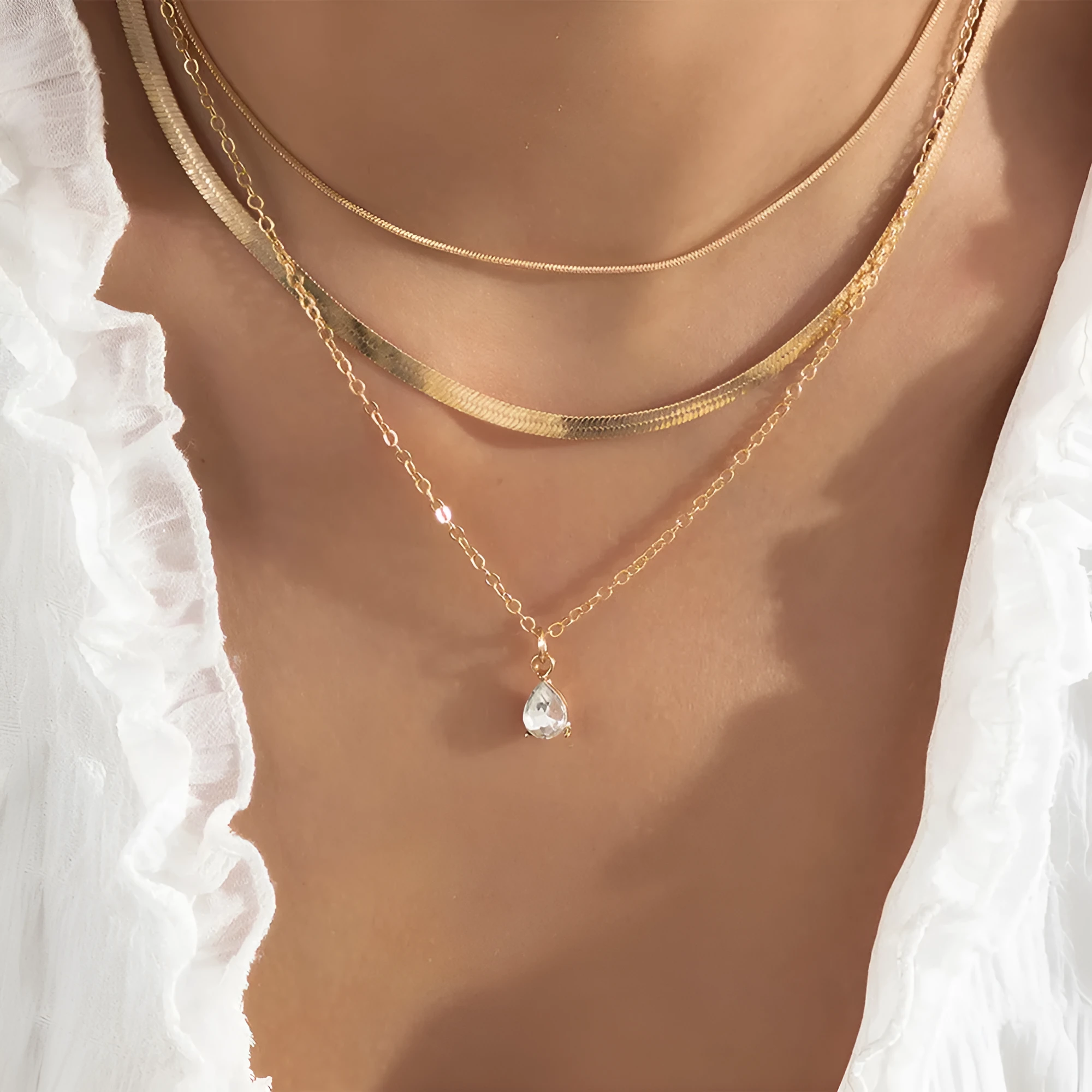Gold and silver water drop shape alloy pendant necklace with electroplated finish on white background