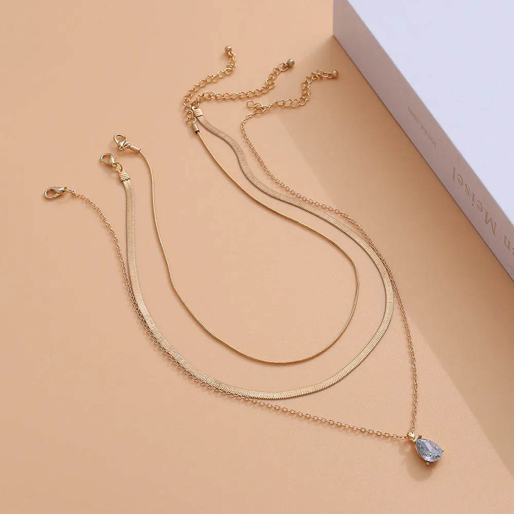 Gold and silver water drop shape alloy pendant necklace with electroplated finish on white background